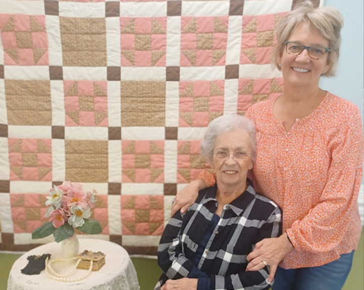 Our passionate skilled caregiver standing by a senior woman whom she provides memory care to.