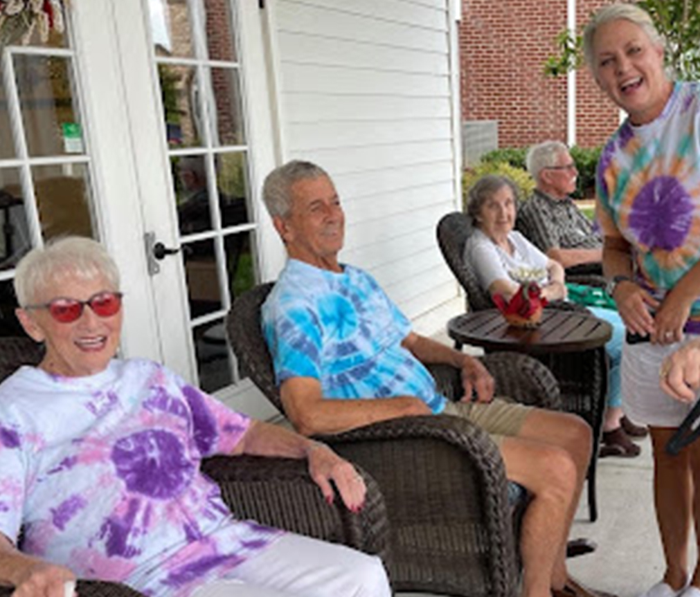 A group of happy seniors sitting together on the porch at our retirement home in the Villages, TN.
