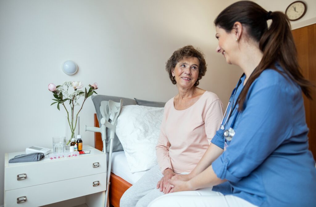 A female nurse and a female independent living patient talking together in the patient's room