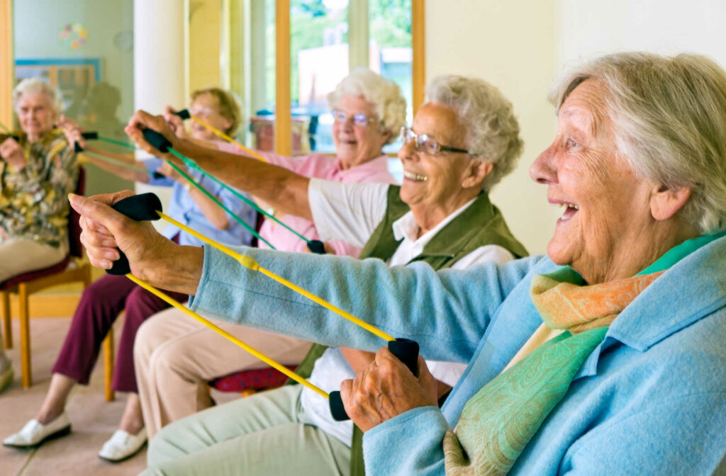 A group of senior living residents using resistance bands for exercise.