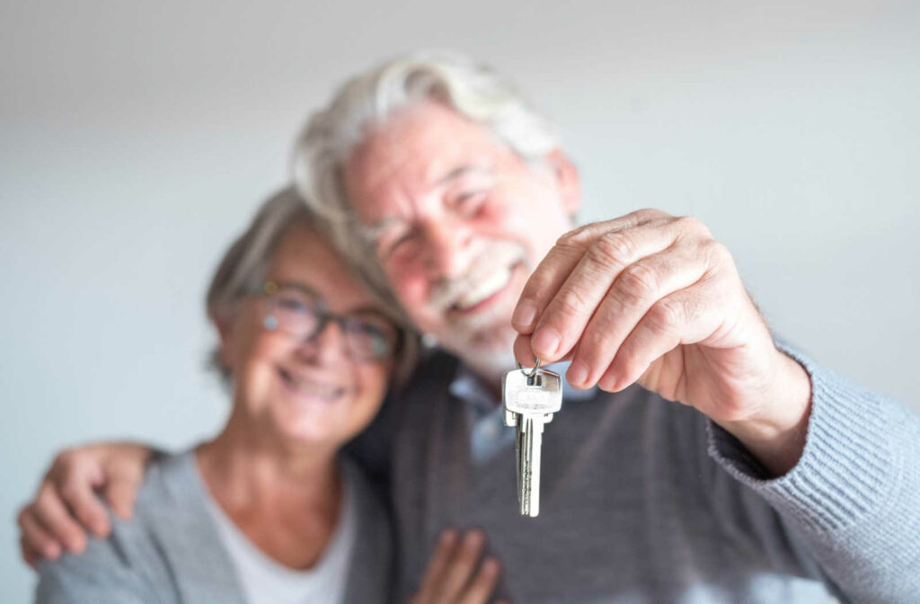 An elderly couple handing over the keys to their forever home as they move into a senior living community.