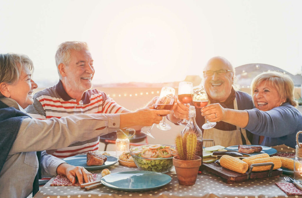 A group of happy seniors enjoying a keto diet lunch together.