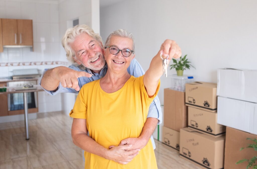 A senior couple handing over the keys to their home.