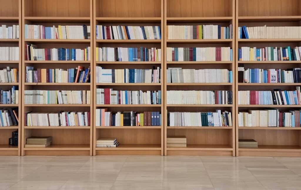 A wall of bookshelves in a senior living community is full of novels and non fiction books waiting to be read by residents.