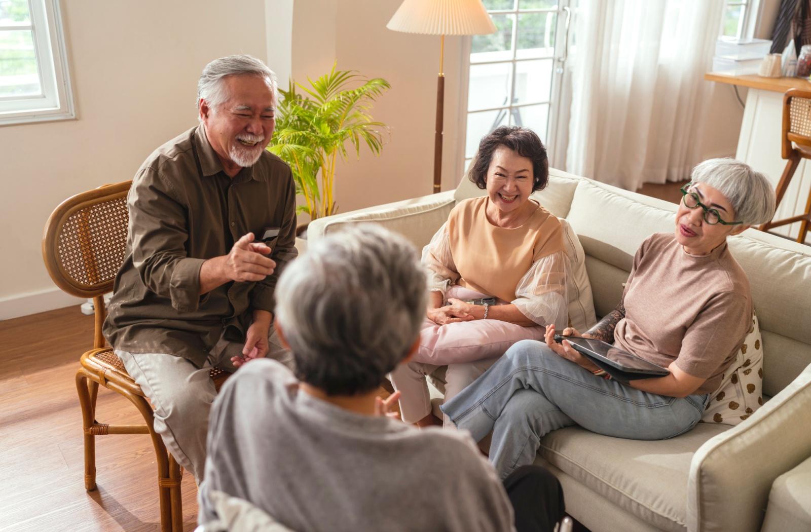 A group of senior friends smile as they play a trivia game.
